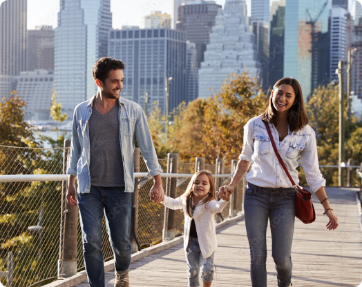 couple with daughter walking across bridge