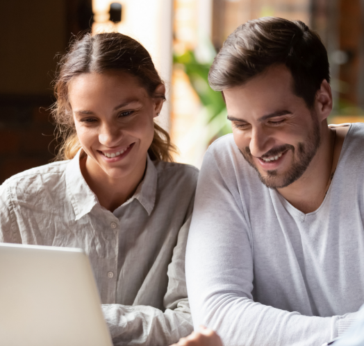 two-people-smiling-looking-at-laptop-cropped