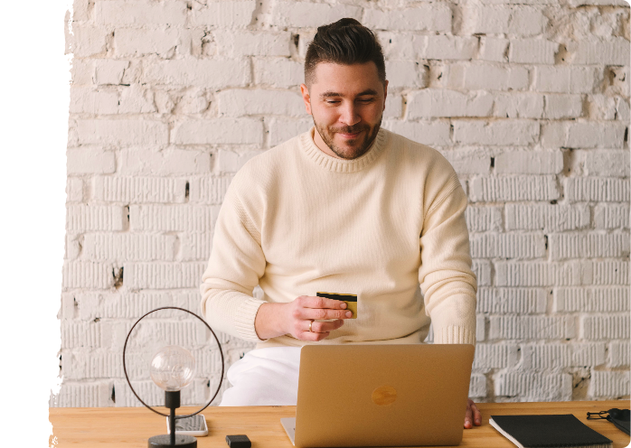 man on laptop holding credit card